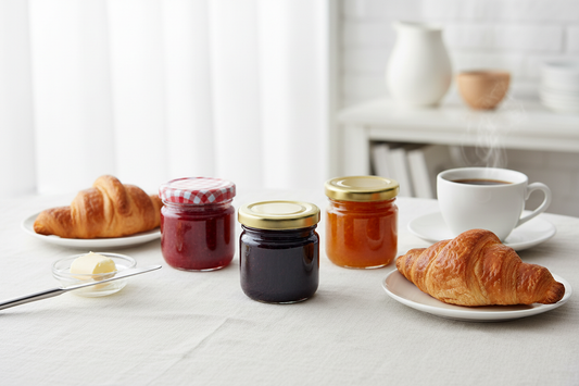 Mesa de desayuno elegante con mermeladas gourmet en envases de vidrio